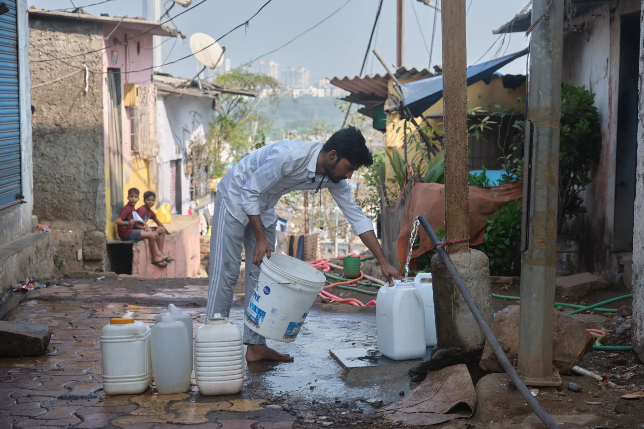 Umesh Ganu, an office attendant, fills containers at a public tap in Thakurpada, a low-income neighborhood in Navi Mumbai. The government supplies water once a week and it is not suitable for drinking. Photo by Shamsheer Yousaf