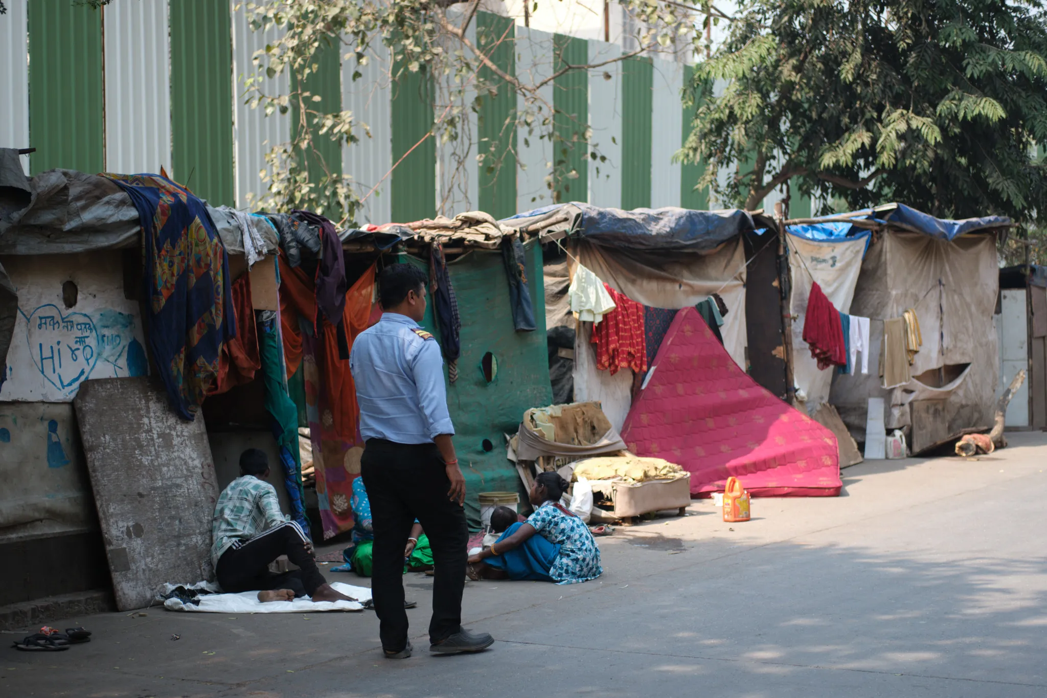 A security officer patrols a row of makeshift homes in Hiranandani Gardens, a sprawling development in Mumbai. Low-income residents were evicted from their homes to make way for a new development that includes data center. Photo by Shamsheer Yousaf